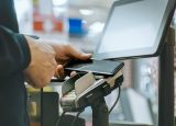 Close up of a mobile phone tapping a card reader to make payment in a shop