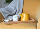 Picture of a yellow teapot on a yellow chair