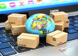 Small globe on a keyboard surrounded by small brown packages