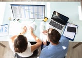 Two Businesspeople Analyzing Gantt Chart On Computer