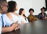 a group of businesswomen speaking at a table