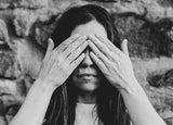 black and white image of a woman holding her hands to her eyes