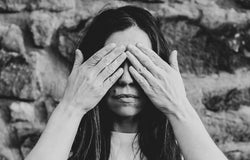 black and white image of a woman holding her hands to her eyes