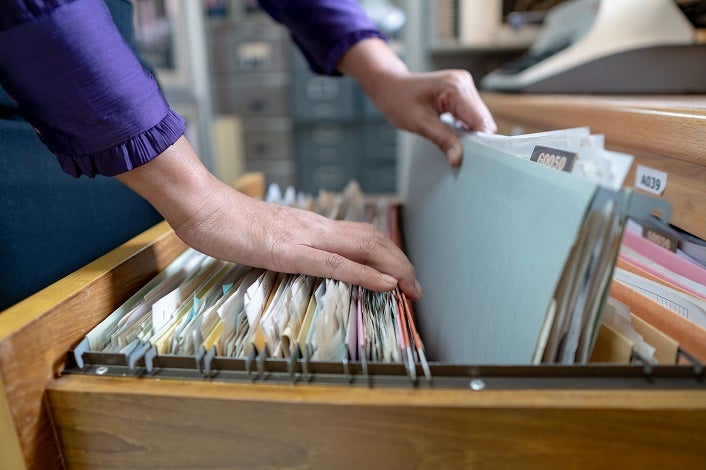 The hand of a woman holds important documents in the office.