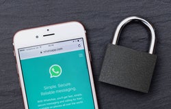 WhatsApp open on a smartphone next to a padlock