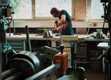 A man using a grinder in a workshop