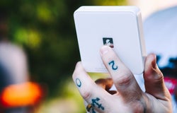 An image of a man holding a SumUp card reader