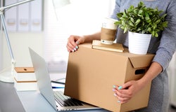 Happy team of businesspeople moving office, packing boxes, smiling