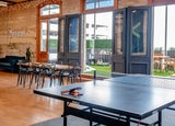 a modern workplace with a meeting table, outdoor space and ping pong table, representing company culture