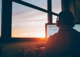 Employee working at a computer at sunset