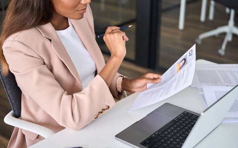 A woman at a desk looking at a candidate's CV