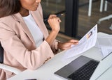 A woman at a desk looking at a candidate's CV