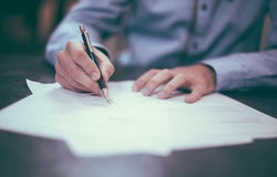 a man writing on paper