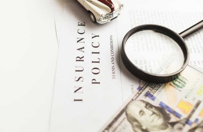 Close up of insurance policy papers with a magnifying glass resting on them