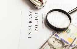 Close up of insurance policy papers with a magnifying glass resting on them