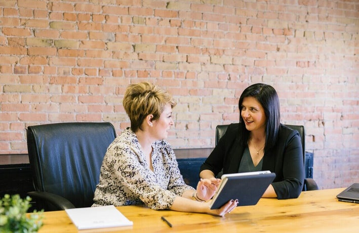 Women looking at a tablet together in an office