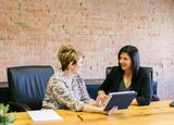 Women looking at a tablet together in an office