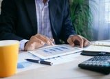 Man sitting at a desk looking at data on a tablet