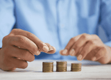 Person counting coins into piles